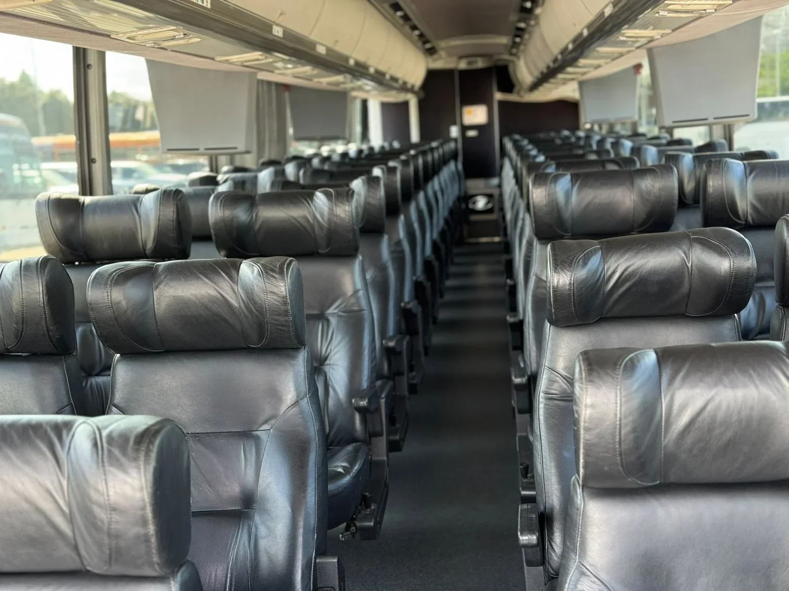 Black leather seats inside a coach bus.